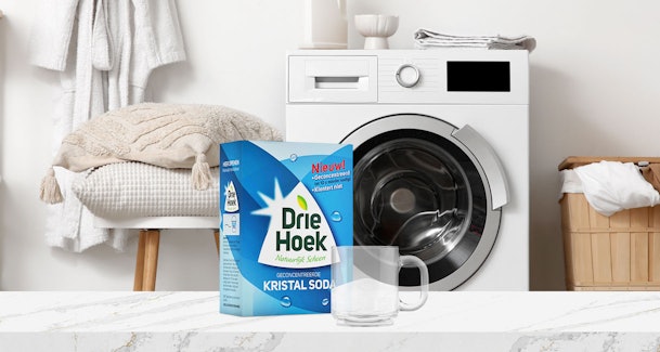 Doos kristalsoda met maatbeker voor het ontkalken van een wasmachine
