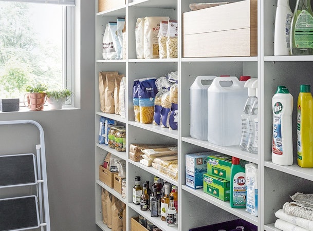 Een bijkeuken met open kasten en planken.