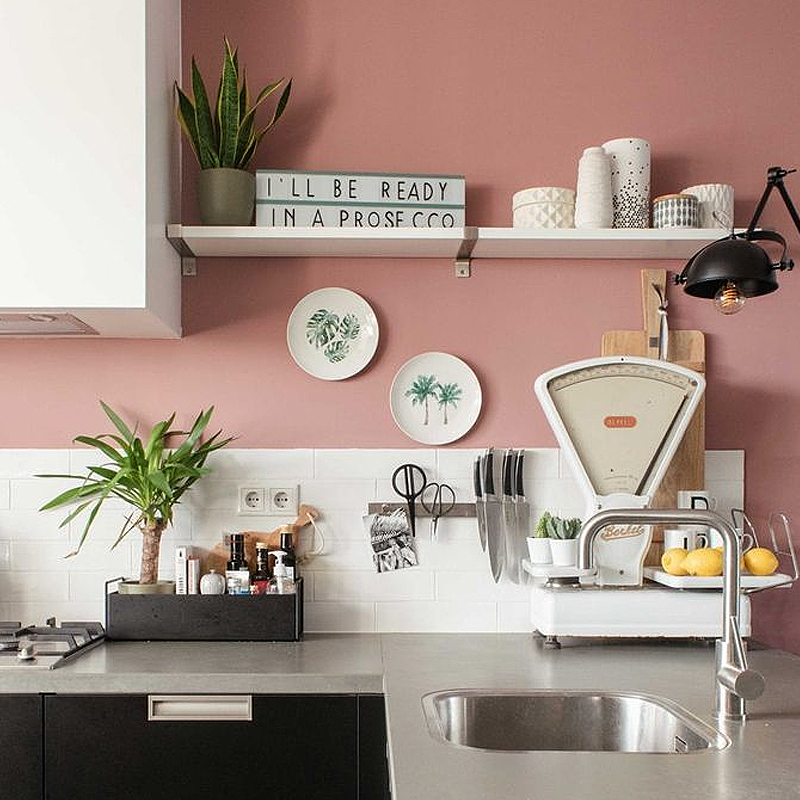 Oud roze muur in een keuken.