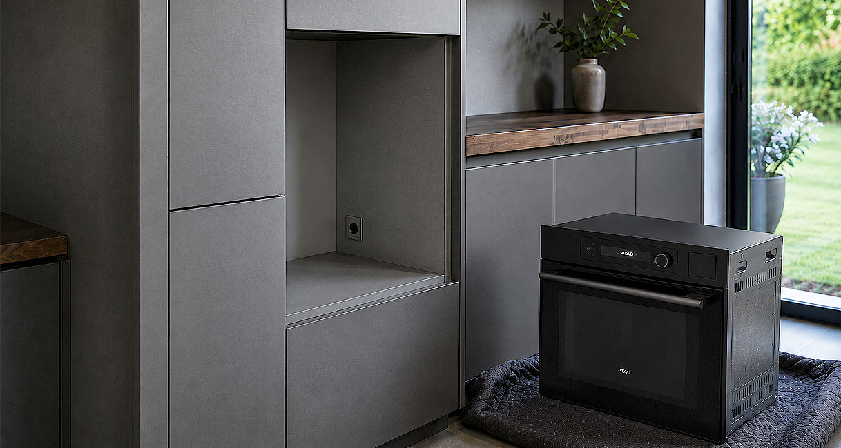 Nieuwe oven staat klaar naast de lege nis met stopcontact in een bestaande keuken