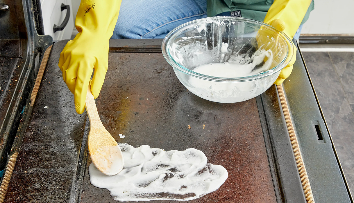 Baking soda-pasta aanbrengen op ovenruit om het glas veilig schoon te maken