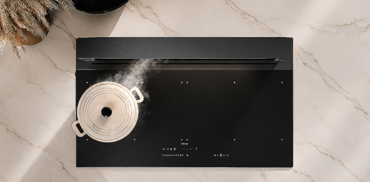 Downdraft afzuigkap naast inductie kookplaat met pan in keuken bovenaanzicht