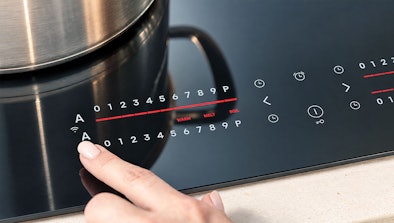 Vinger bedient de slider met kookstanden op een Pelgrim inductiekookplaat