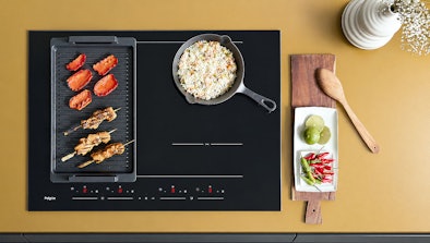 Grillplaat en pan op twee gekoppelde kookzones van een Pelgrim inductiekookplaat