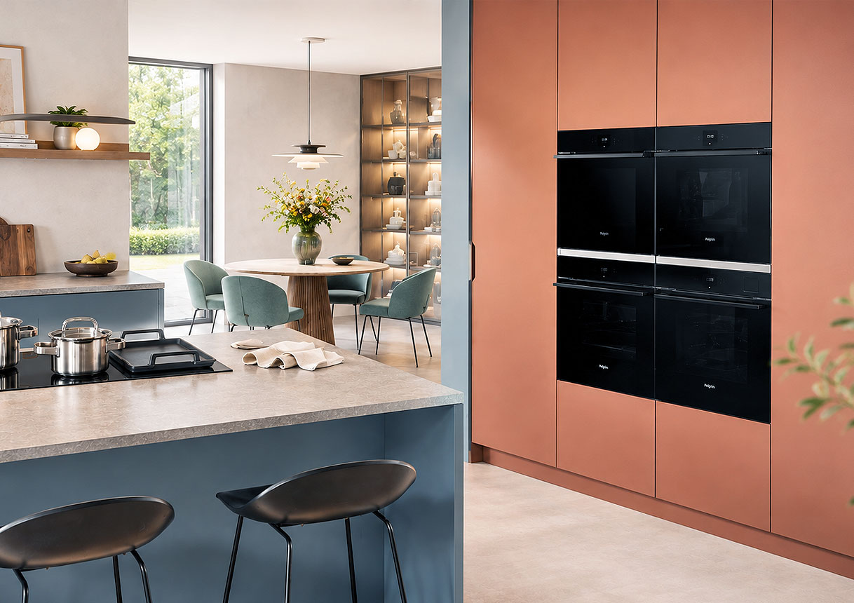 Twee Pelgrim ovens boven elkaar ingebouwd in een terracotta kastenwand naast de eettafel
