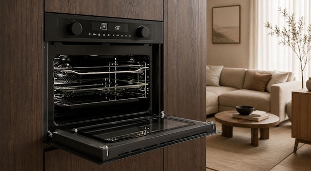 Pelgrim oven met magnetronfunctie en open deur, ingebouwd in een donkerbruine houten keukenkast.