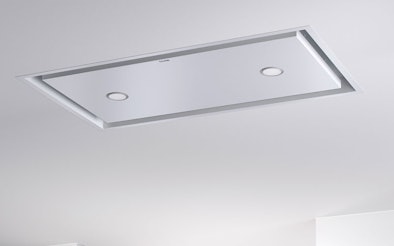 Plafondunit afzuigkap volledig geïntegreerd in het plafond boven de kookplaat voor een strakke en open keuken.