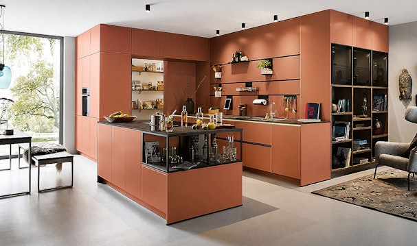 Moderne terracotta keuken met eiland, open vakkenwand en zwart werkblad