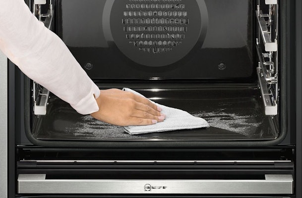 Binnenkant van een oven wordt na een pyrolyse-reinigingsprogramma afgeveegd met een doek