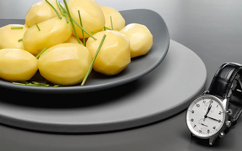 Gekookte aardappelen met horloge ter illustratie van Miele Quick Steam functie voor snelle stoomresultaten