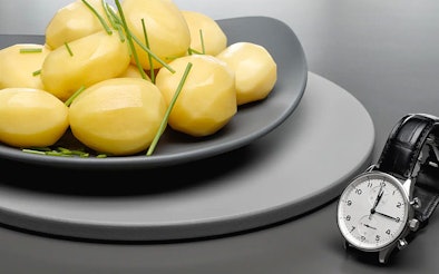 Gekookte aardappelen met horloge ter illustratie van Miele Quick Steam functie voor snelle stoomresultaten