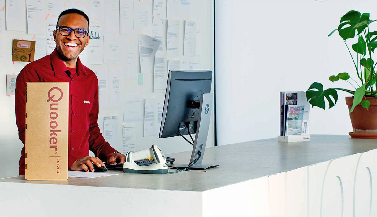Quooker servicemedewerker achter balie met Quooker Service doos