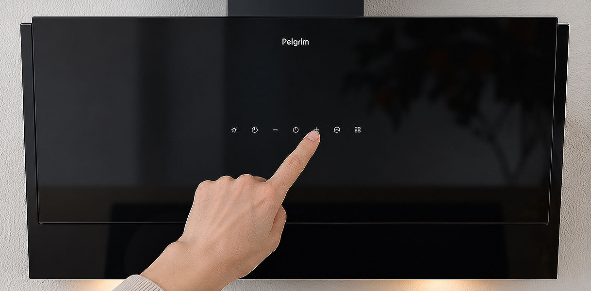 Vinger bedient de touch-toetsen op het glazen front van een Pelgrim afzuigkap