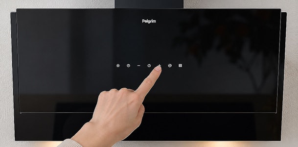 Vinger bedient de touch-toetsen op het glazen front van een Pelgrim afzuigkap