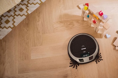 Miele robotstofzuiger reinigt zelfstandig houten vloer tussen speelgoed en tapijt in kinderkamer