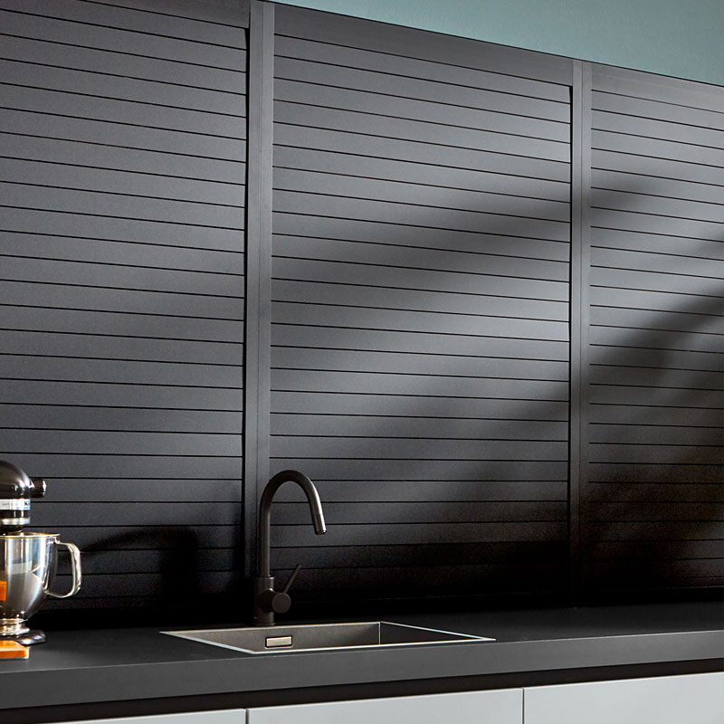 Zwarte roldeurwand met horizontale lamellen en matte afwerking.