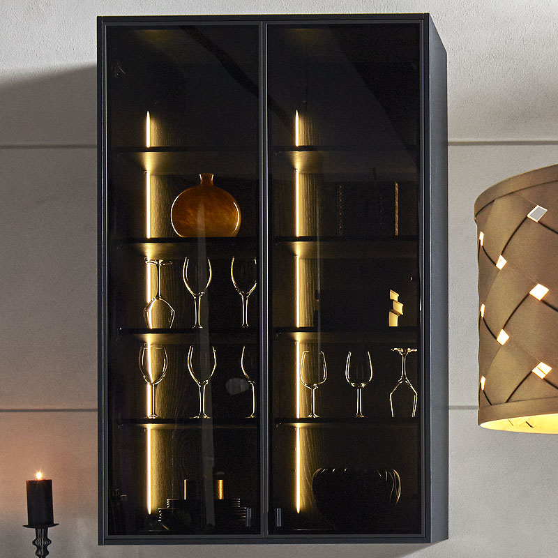 Hangende rookglas vitrine met slanke planken en warme gloed.