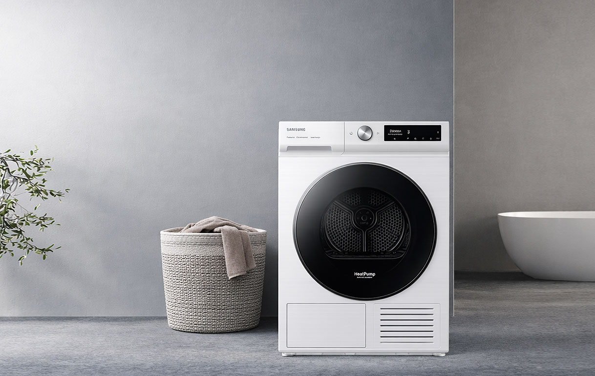 Samsung warmtepompdroger 7000-serie in wit met premium glazen deur in moderne wasruimte met rieten wasmand