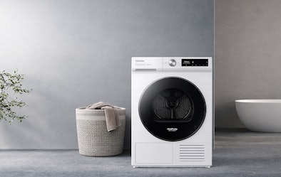 Samsung warmtepompdroger 7000-serie in wit met premium glazen deur in moderne wasruimte met rieten wasmand