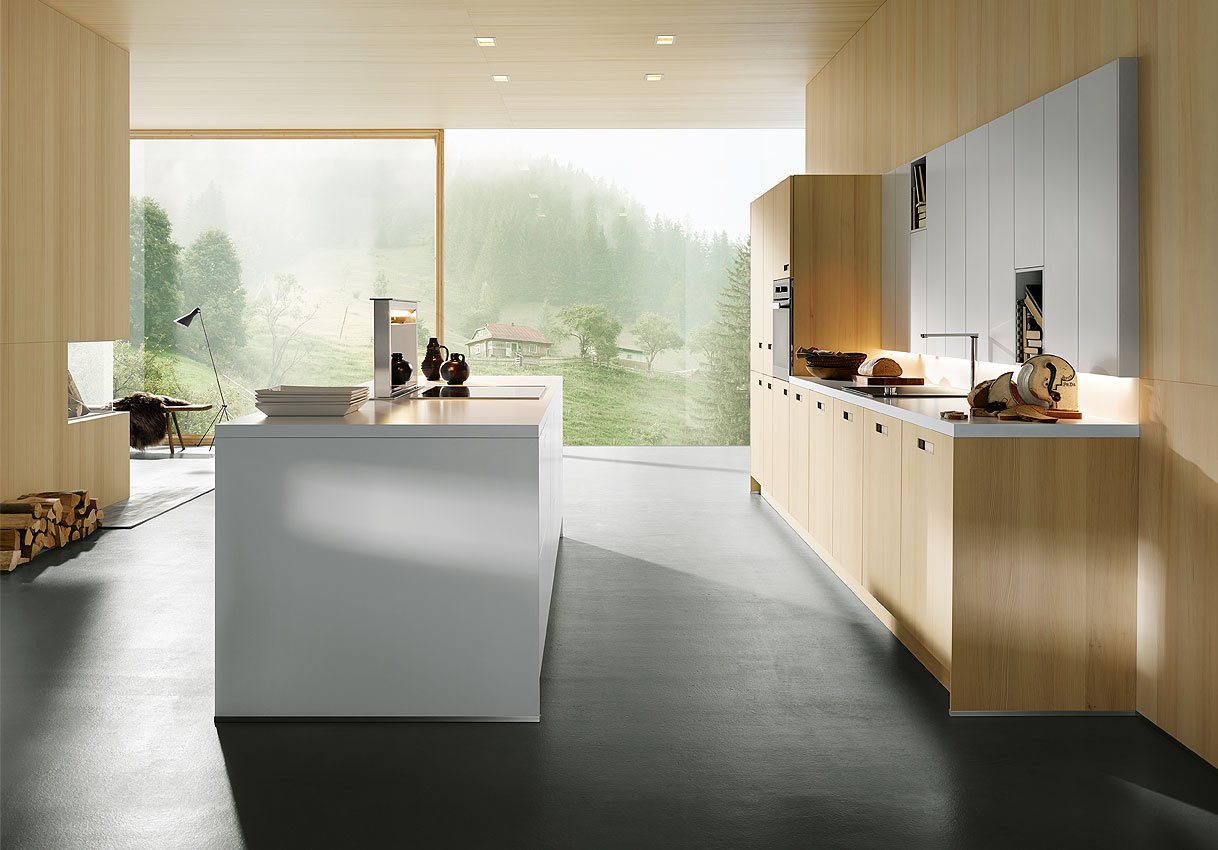 Lichte Scandinavische keuken met houten accenten, kookeiland en grote raampartijen met uitzicht op de natuur