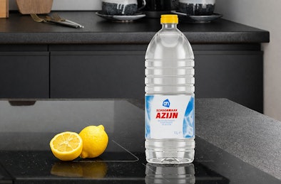 Fles schoonmaakazijn en citroen op inductiekookplaat