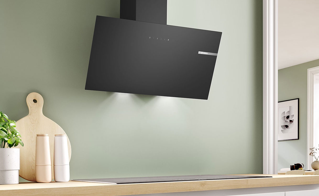 Zwarte schuine afzuigkap van 80 cm boven een inductiekookplaat in een moderne keuken.