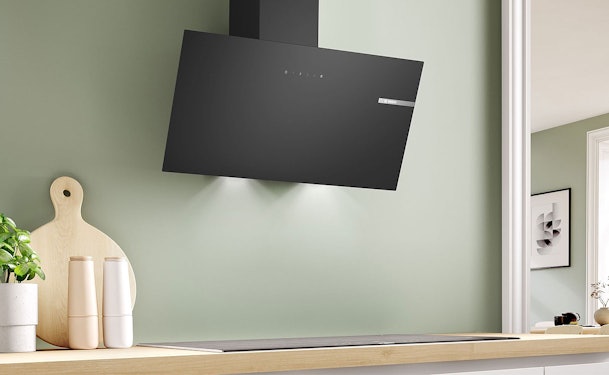 Zwarte schuine afzuigkap van 80 cm boven een inductiekookplaat in een moderne keuken.
