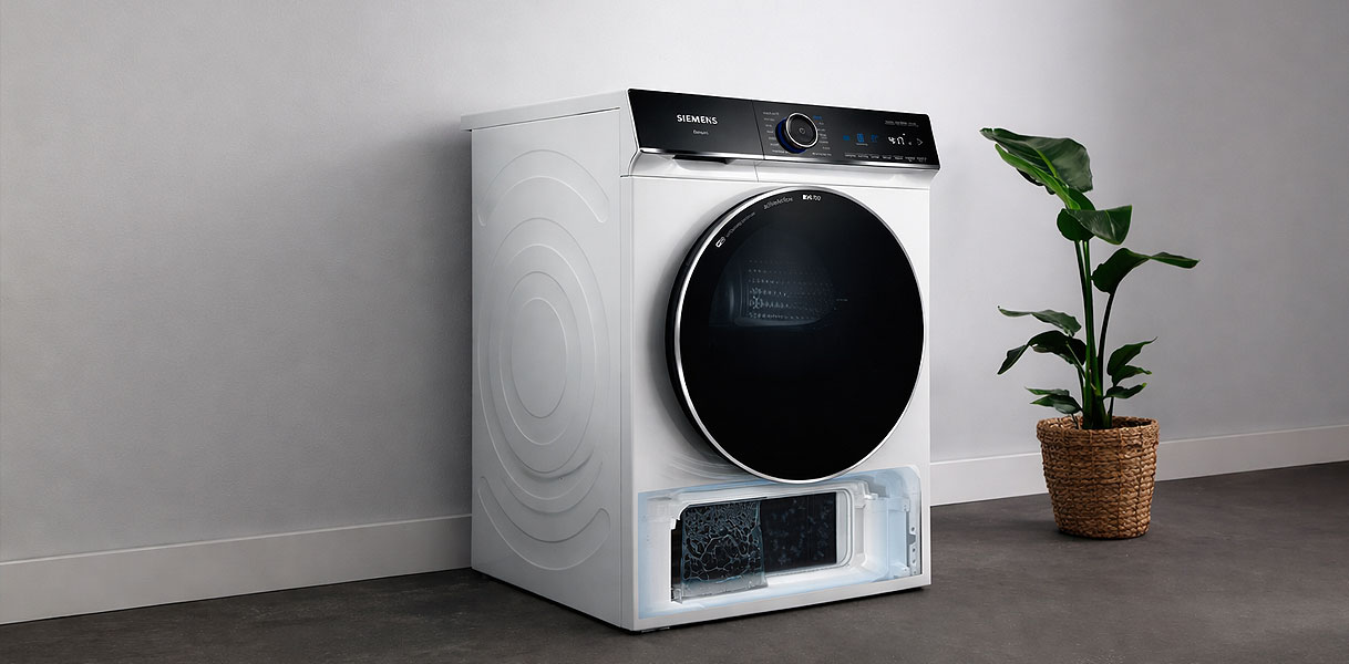 Siemens droger met geopende selfCleaning Condensor lade in moderne wasruimte met plant
