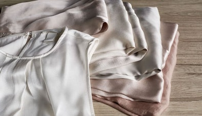 Zacht gedroogde kleding gevouwen op houten ondergrond dankzij ASKO Sensi Dry technologie