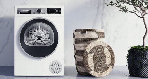 Bosch warmtepompdroger Serie 6 met grote trommel in moderne wasruimte met rieten manden, ideaal voor gezinnen