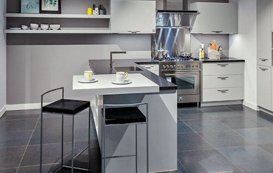 Strakke L-showroomkeuken met RVS fornuis