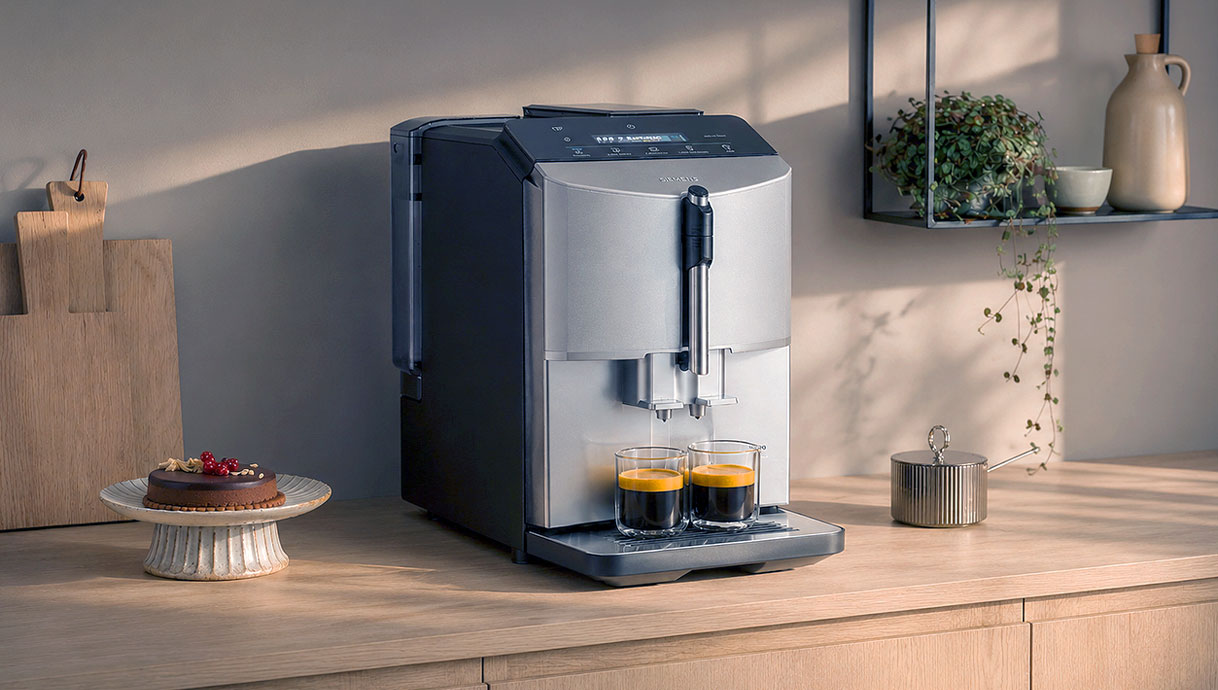 Siemens EQ.300 koffiemachine op een aanrecht met twee espresso's en een taart ernaast
