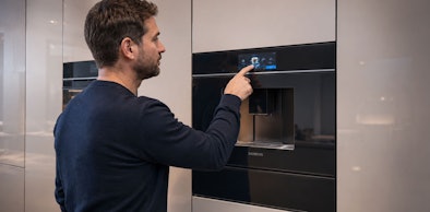 Man bedient het touchdisplay van een Siemens inbouw koffieautomaat op ooghoogte