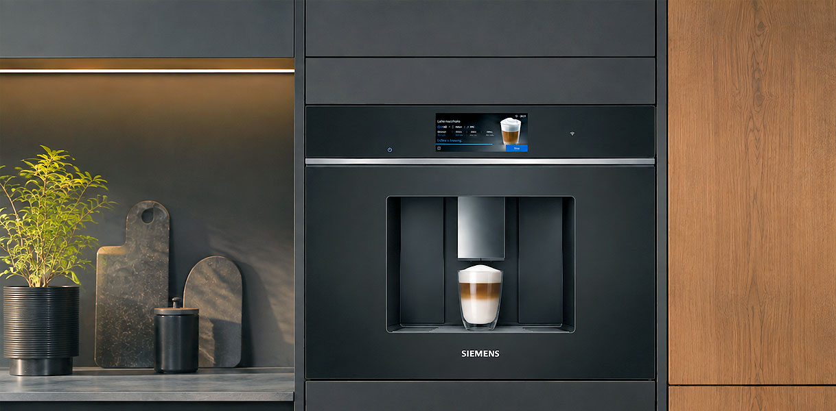 Siemens CT718 iQ700 inbouw koffiemachine in zwart naast een keukenwand met latte macchiato