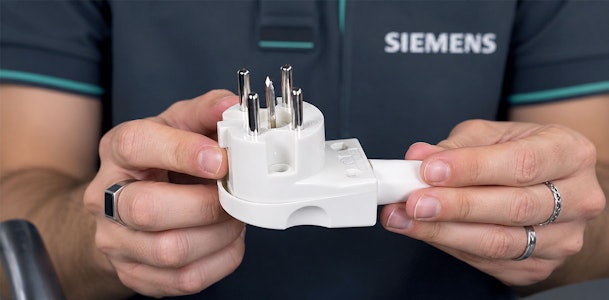 Monteur toont een Perilex stekker voor de aansluiting van een Siemens inductie kookplaat