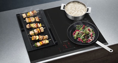 Siemens iQ500 inductiekookplaat met afzuiging en FryingSensor Pro met pannen op het kookoppervlak