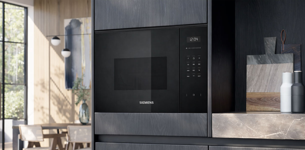 Siemens magnetron met grill ingebouwd in donkere keukenkasten met natuurstenen werkblad