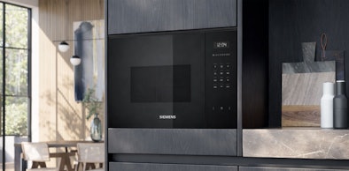 Siemens magnetron met grill ingebouwd in donkere keukenkasten met natuurstenen werkblad