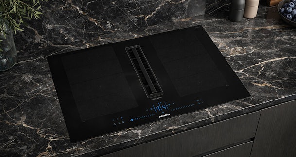 Siemens studioLine inductiekookplaat met afzuiging in premium design op een donker keukenblad