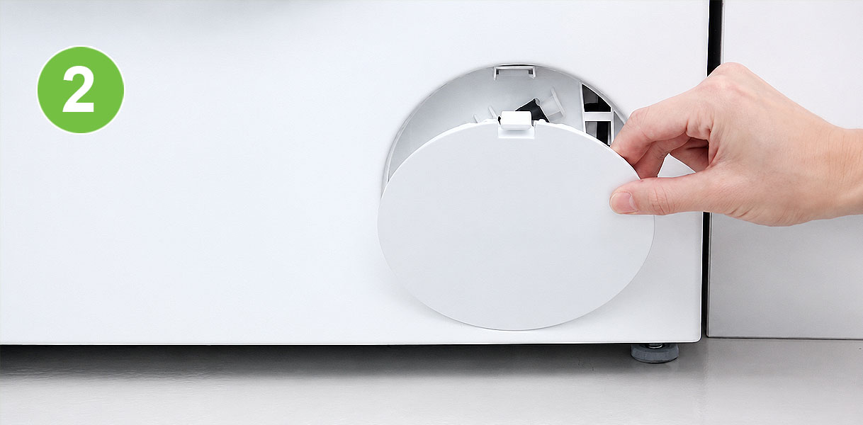 Hand opent het klepje rechtsonder aan de voorkant van een Siemens wasmachine bij storing E18