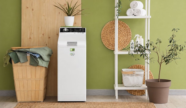 Smalle bovenlader wasmachine in moderne wasruimte, ideaal voor kleine ruimtes en smalle nissen.