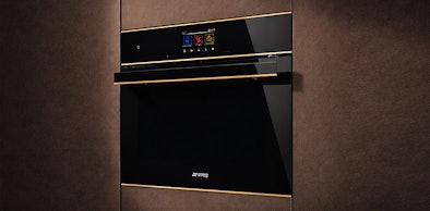 Smeg magnetron met ovenfunctie in donkere bronzen keukenkasten met touchbediening en goudkleurig handvat