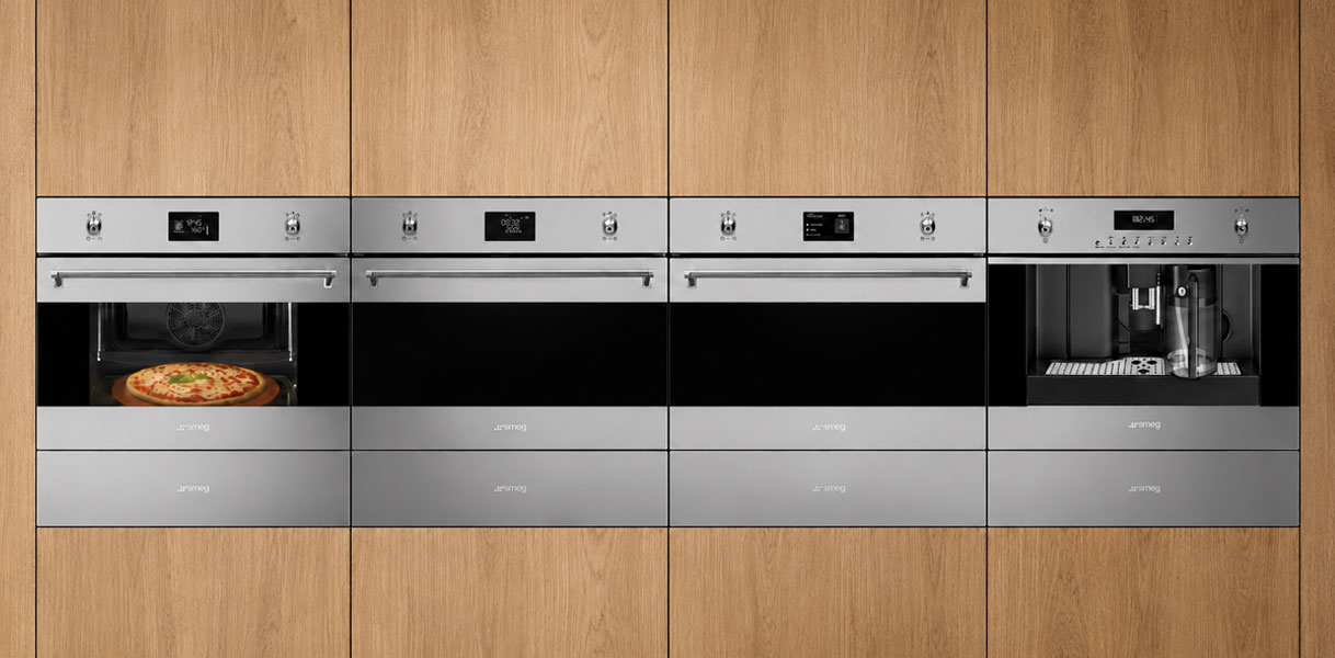 Vier Smeg ovens uit de Classici designlijn in roestvrijstaal naast elkaar in houten kastenwand