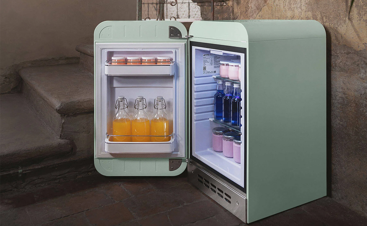 Smeg tafelmodel koelkast in mintgroen met open deur en gevulde koelvakken