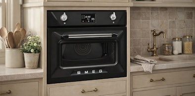 Smeg zwarte inbouw magnetron met retro design en gouden accenten in landelijke beige keuken