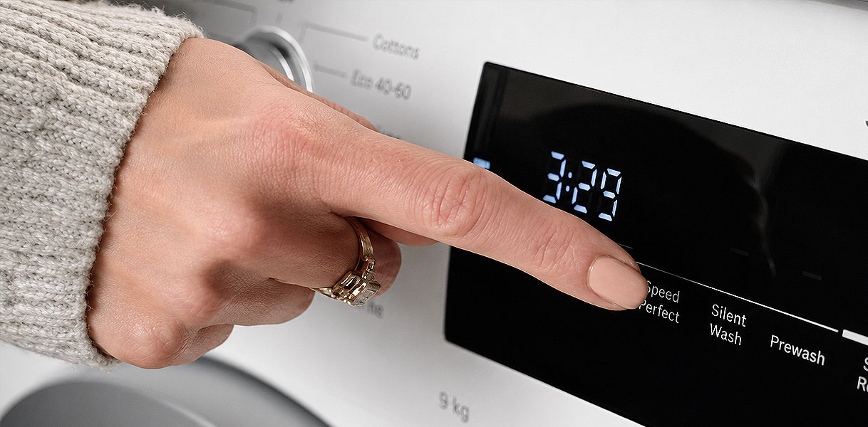 Vinger drukt SpeedPerfect in op Bosch Serie 4 wasmachine die bijna elk programma versnelt