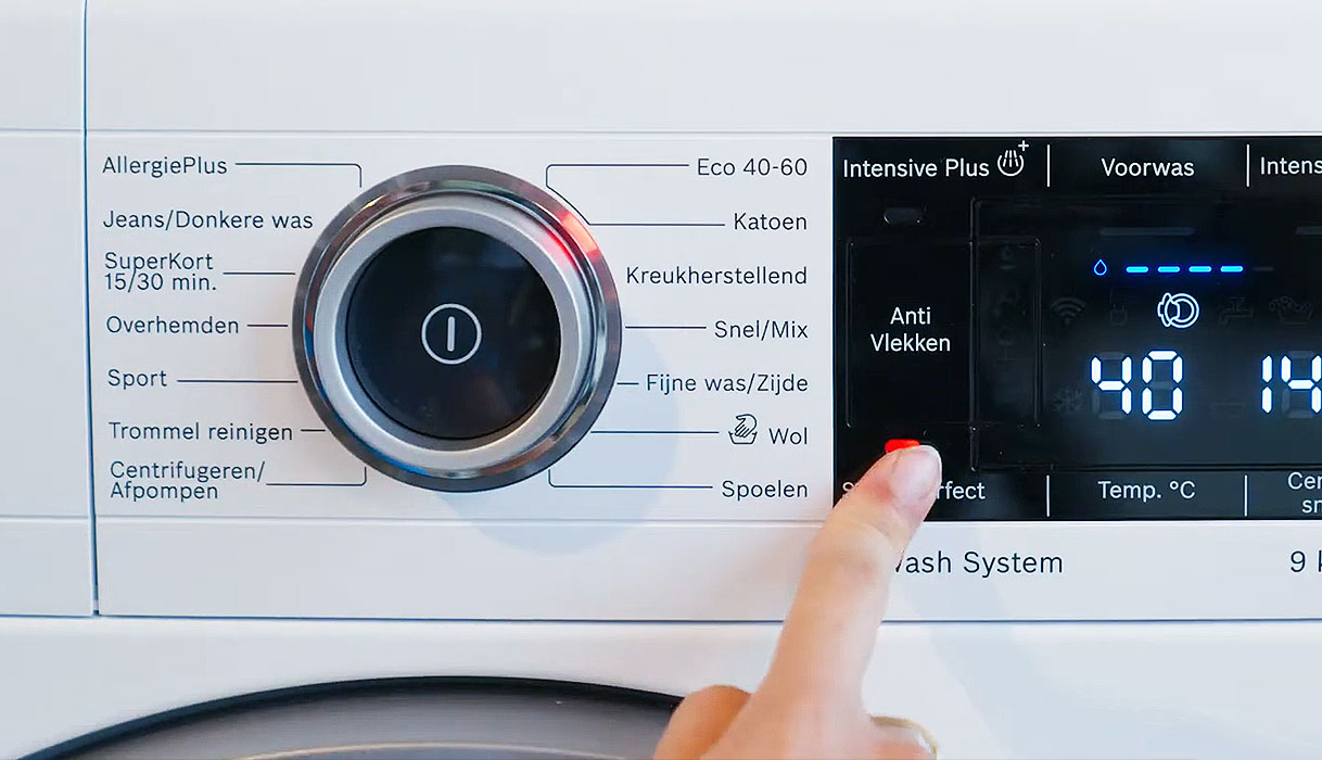 Vinger drukt SpeedPerfect knop op bedieningspaneel van Bosch wasmachine