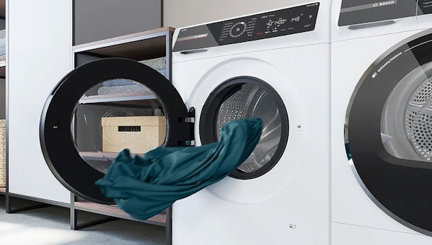 Kleding wordt in Bosch wasmachine geplaatst voor snelle wasbeurt met SpeedPerfect