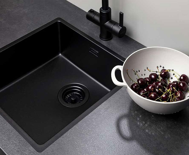 Zwarte spoelbak in moderne keuken.