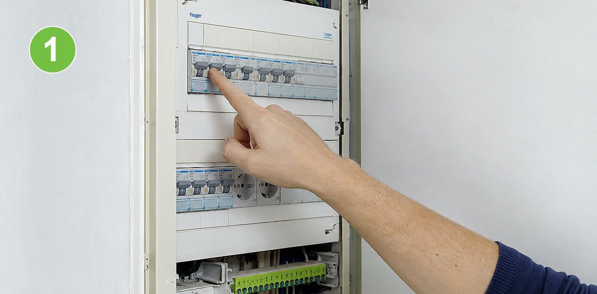 Hand schakelt de stroom uit in de meterkast als voorbereiding voor afzuigkap